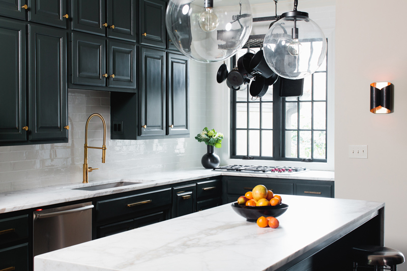 Beautiful interior design in kitchen with black cabinets and white marble countertops