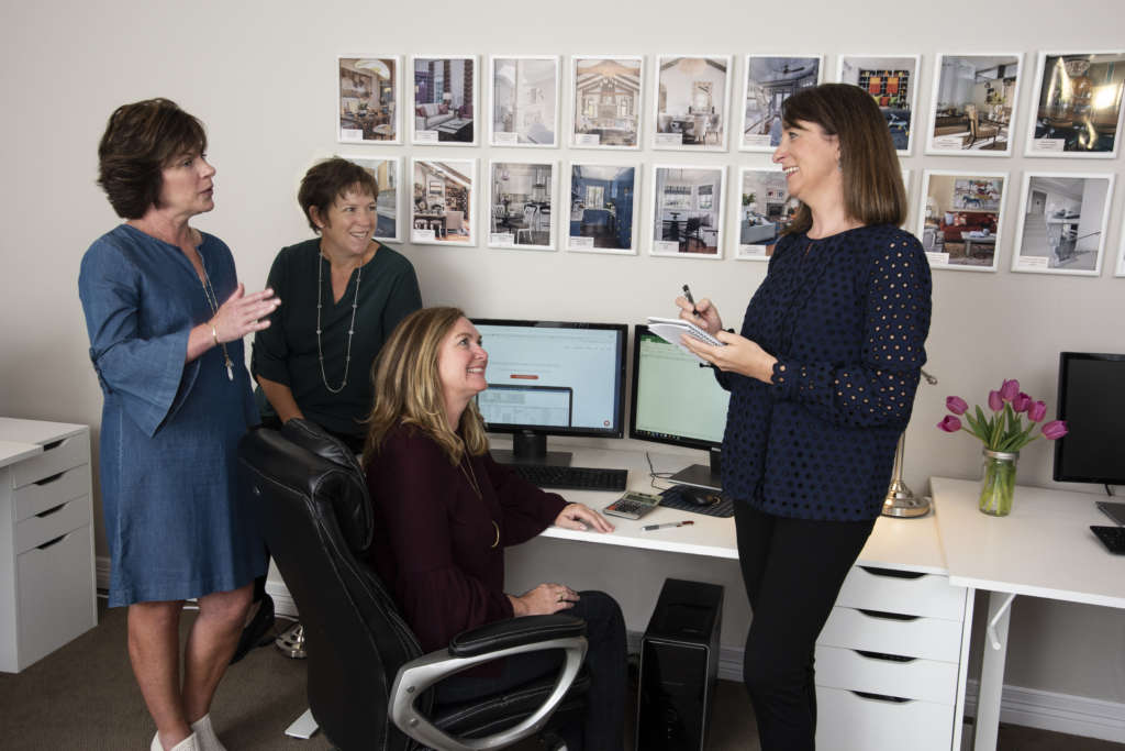 Four women collaborating near a computer at Stemper & Associates